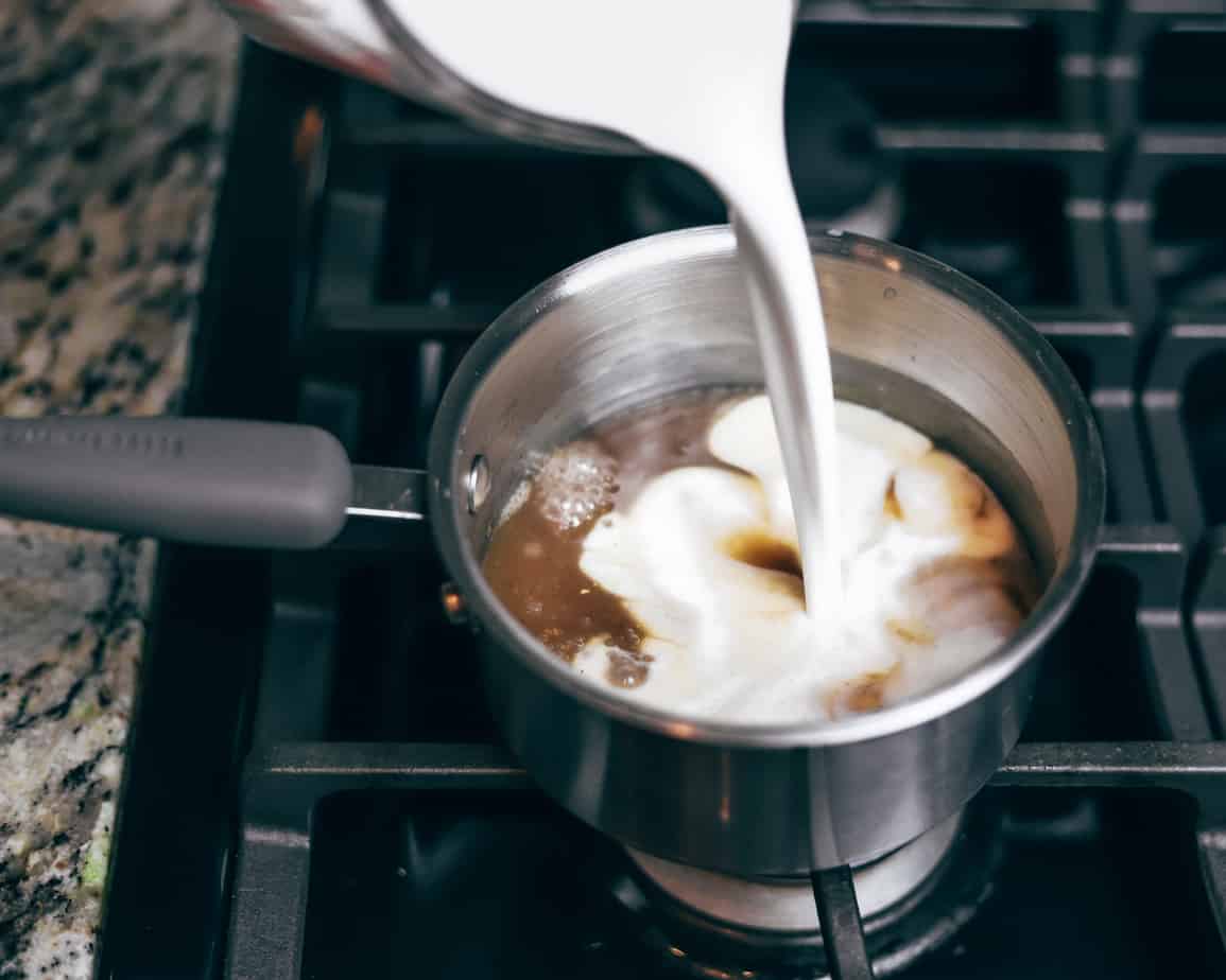 Coconut milk pours and swirls into a pot of heated condensed milk
