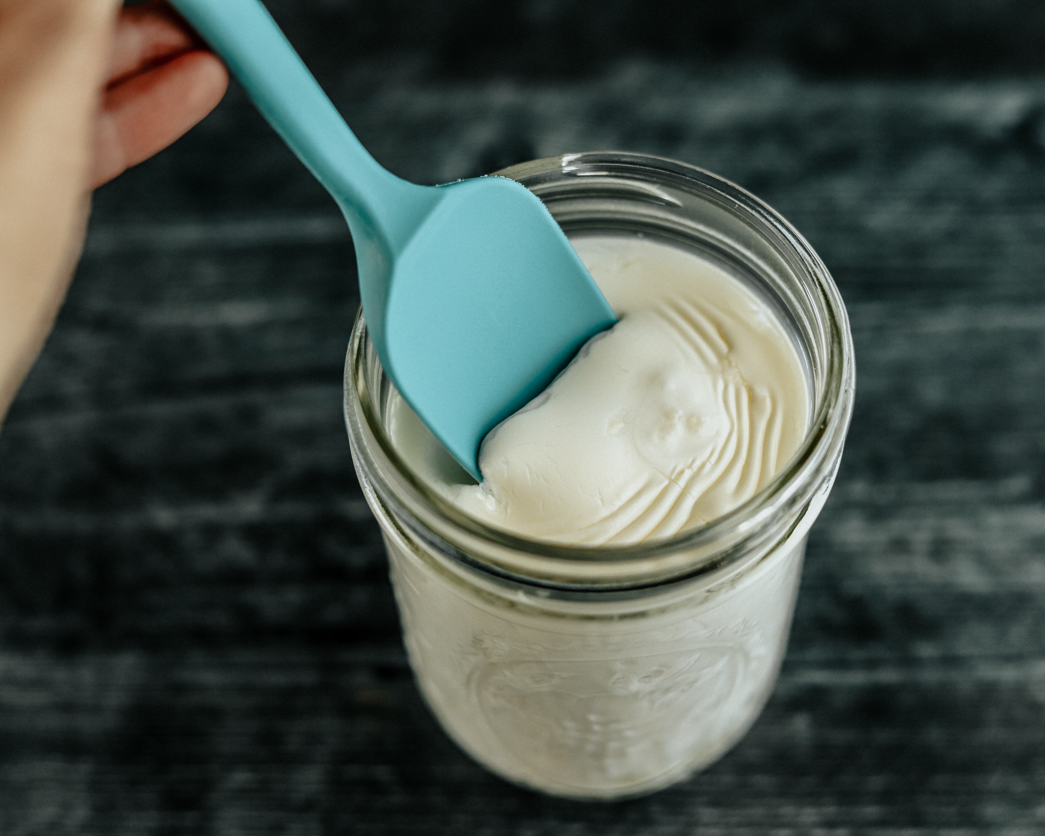 Silicone scraper scoops the top of kefir to ensure that it's been thickened and fermented