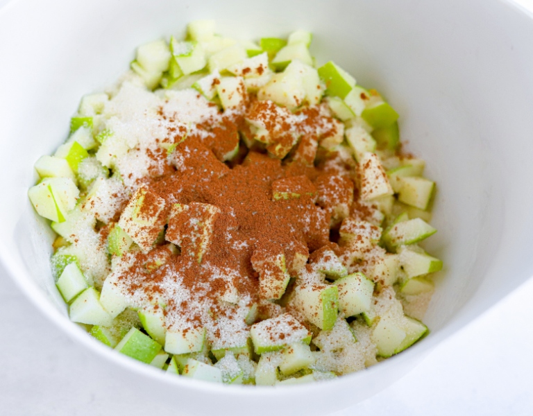 diced apples tossed in cinnamon and sugar for baking