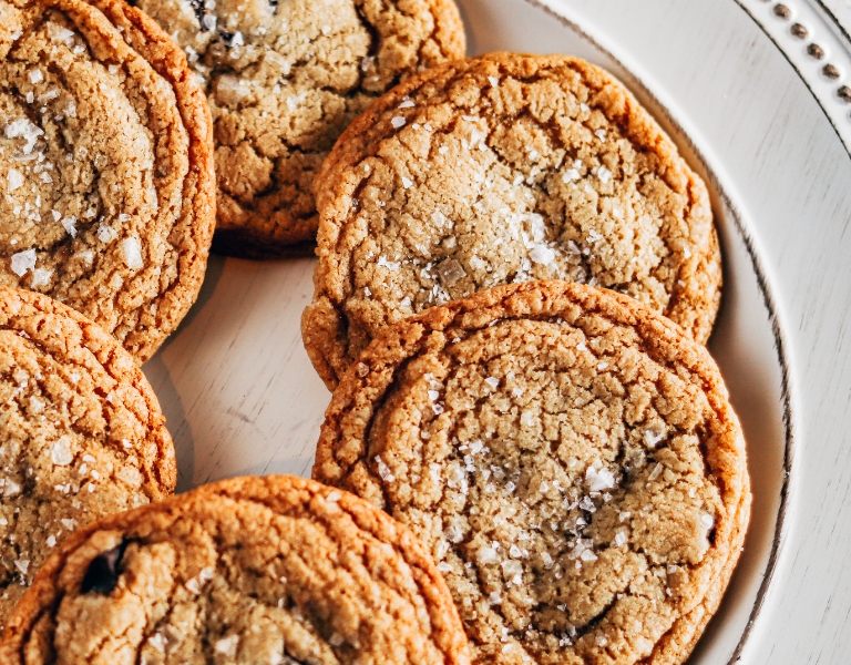 white plate with freshly baked brown butter chocolate chip cookies