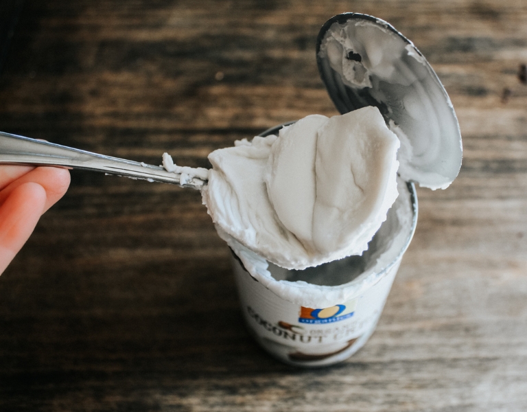spoon scooping out coconut cream from a can