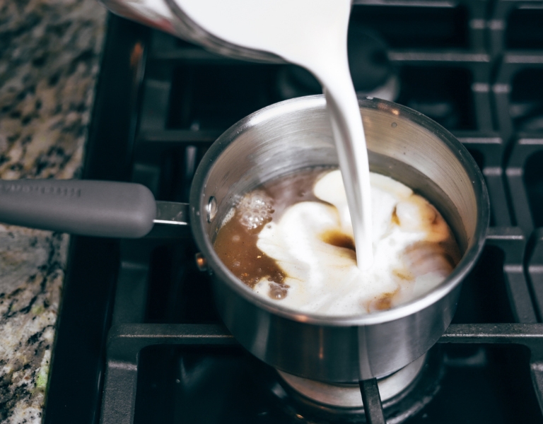 coconut milk is poured into a pot to make vegan coffee creamer
